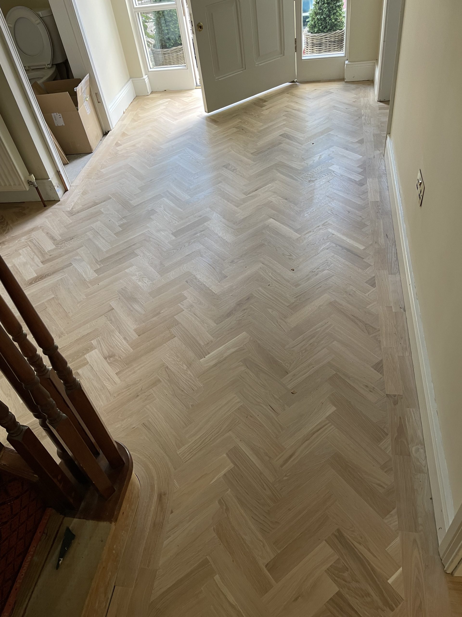 Finished oak herringbone floor with a two-block border fitted consistently around the room