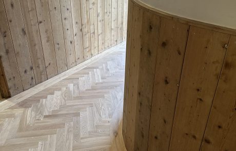 Oak herringbone flooring around curved wall Oak herringbone flooring fitted around a curved timber-clad wall