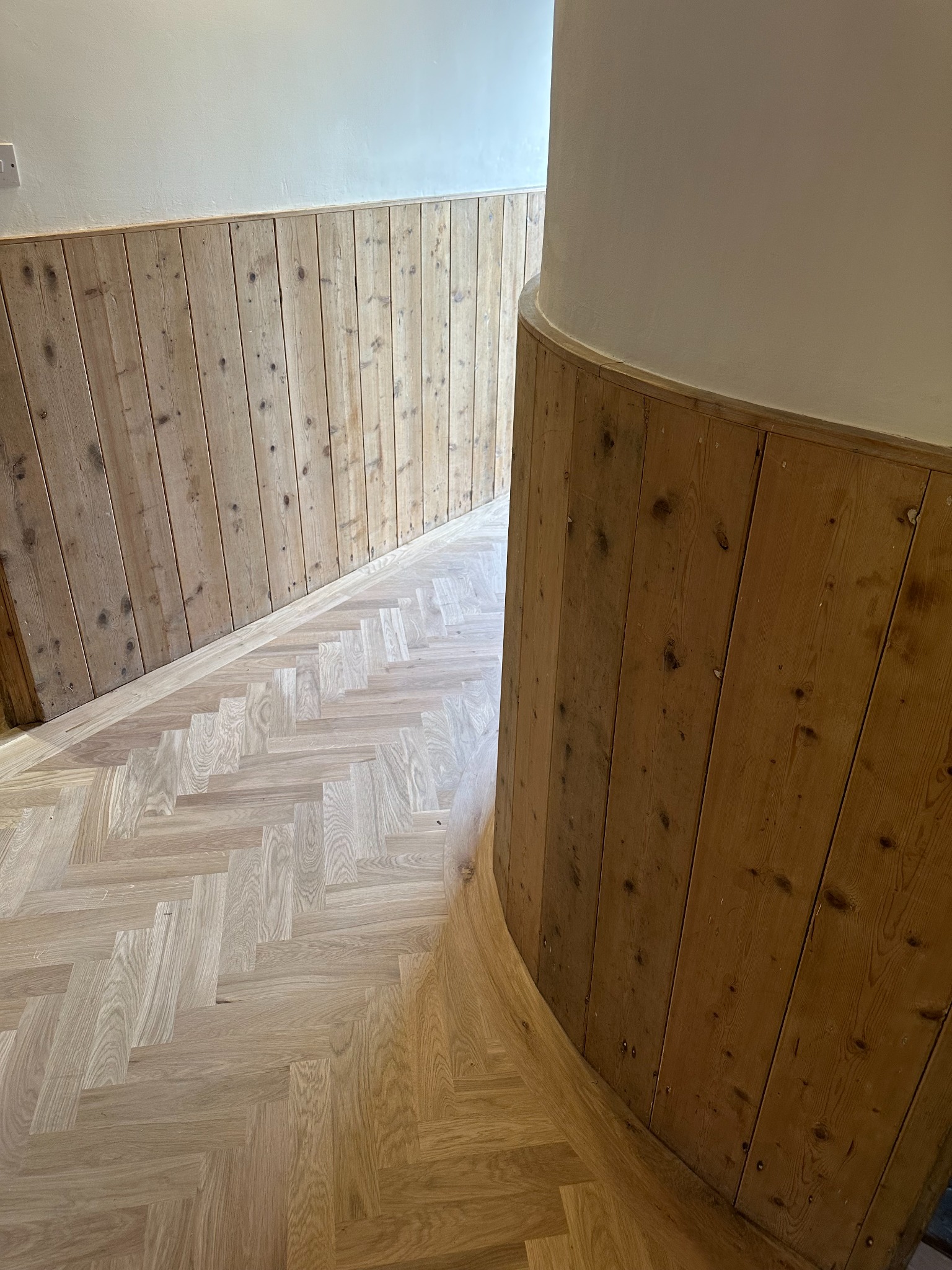 Curved Oak Border Around Rounded Wall Oak herringbone flooring with a curved border following a rounded wall