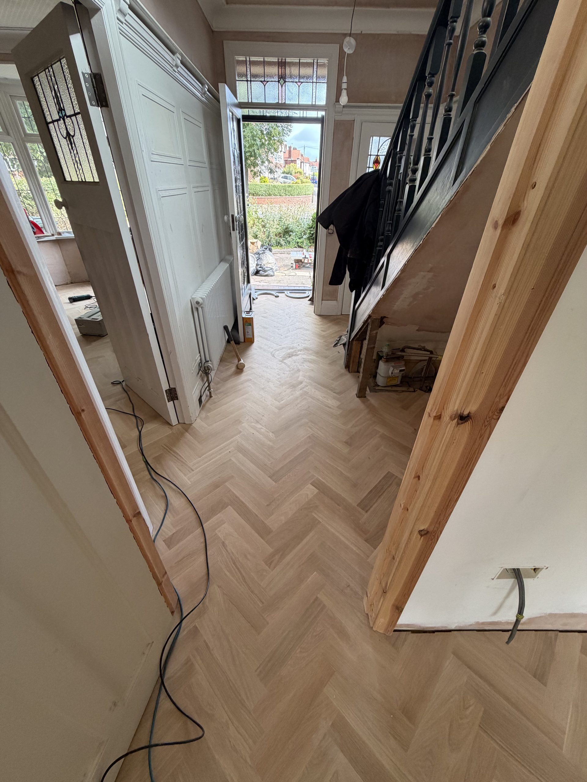 Solid Oak Herringbone Installation – Tynemouth Solid oak herringbone flooring being installed continuously through the hallway and adjoining rooms in Tynemouth