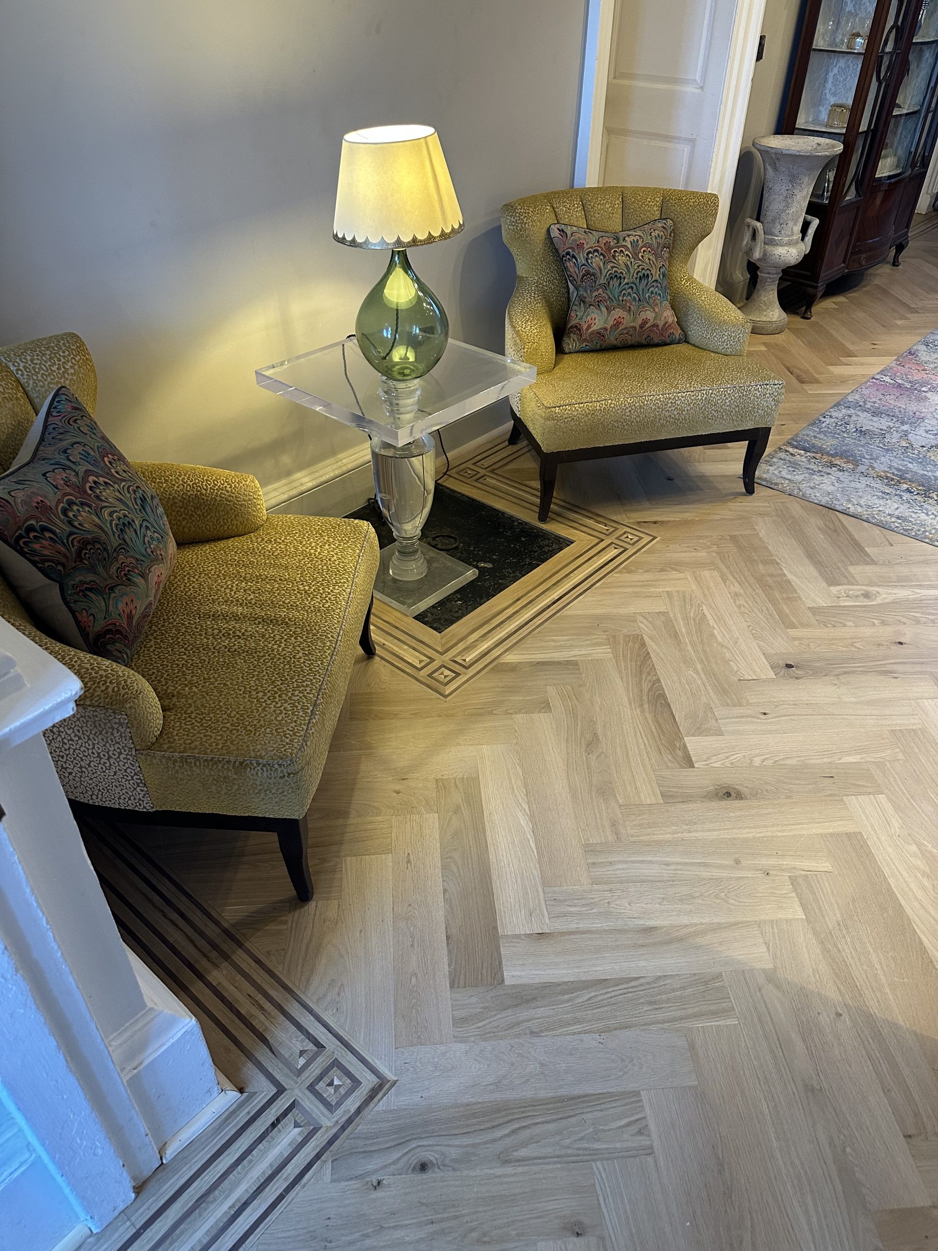 Handmade Border Around Floor Feature Oak parquet flooring with handmade multi-species border formed around an existing floor feature