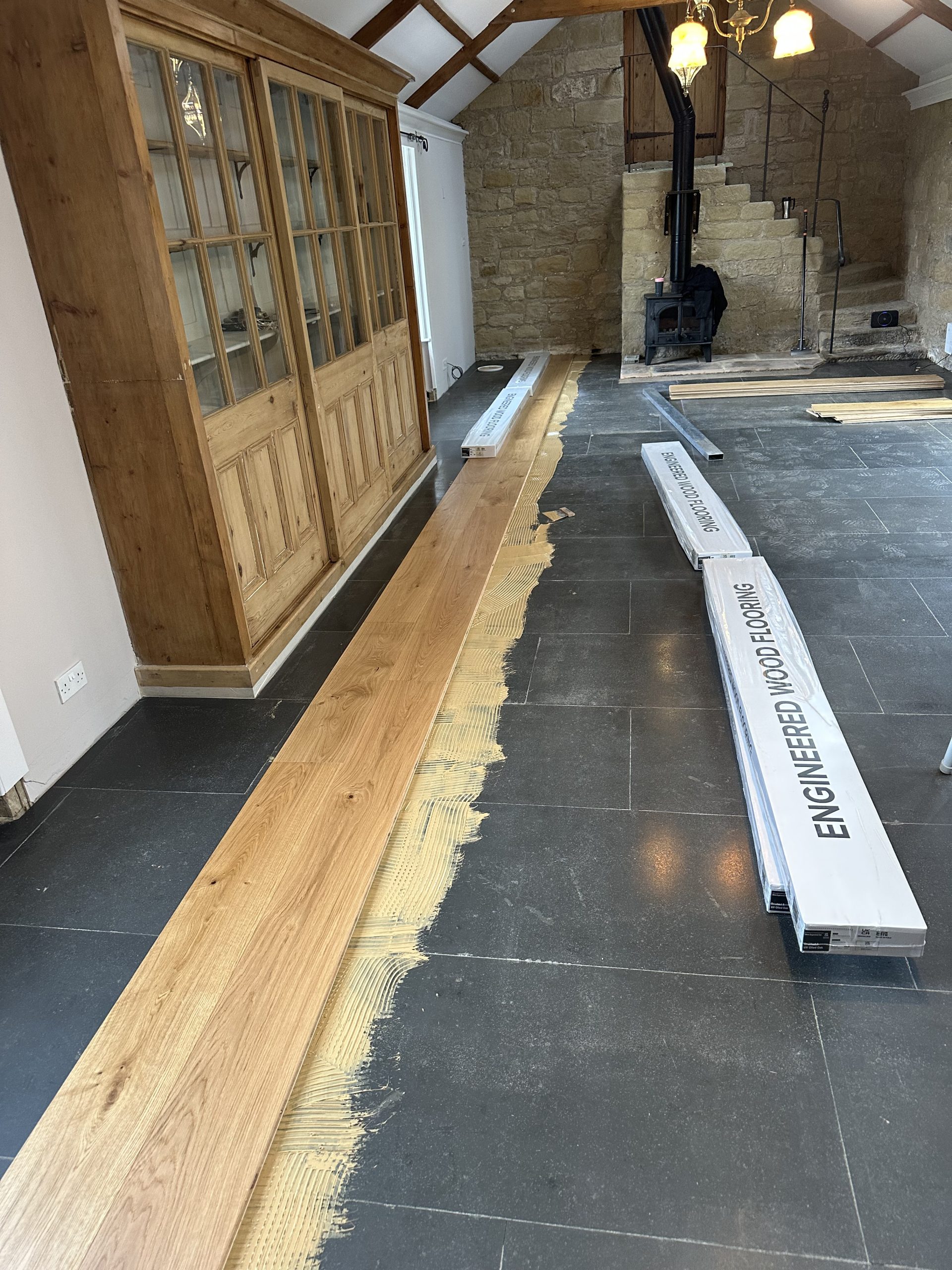 Wide engineered oak planks being installed in a living area in High Buston, Northumberland